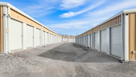 Storage units with white doors and a tan exterior.