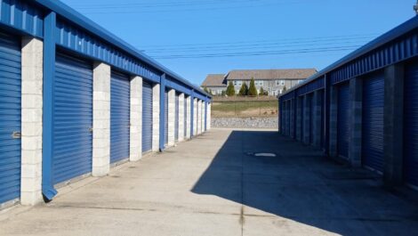 Blue storage units with paved walkway.