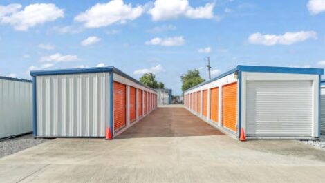 White outdoor storage units with orange doors.