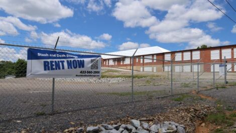 Rent now sign on fence at Stash and Dash Storage.